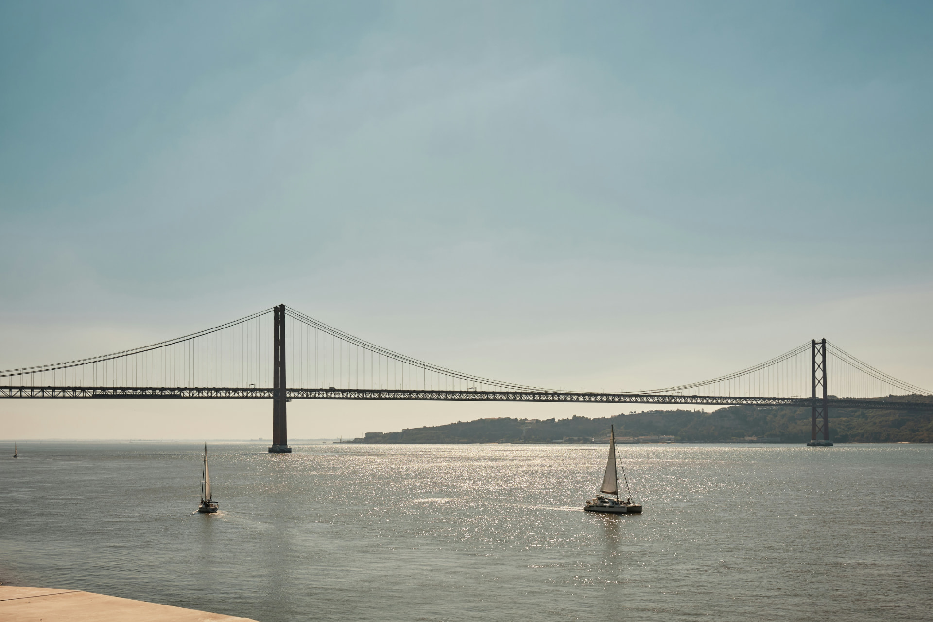 Vista de Lisboa ao entardecer, com o rio Tejo e a Ponte 25 de Abril ao fundo