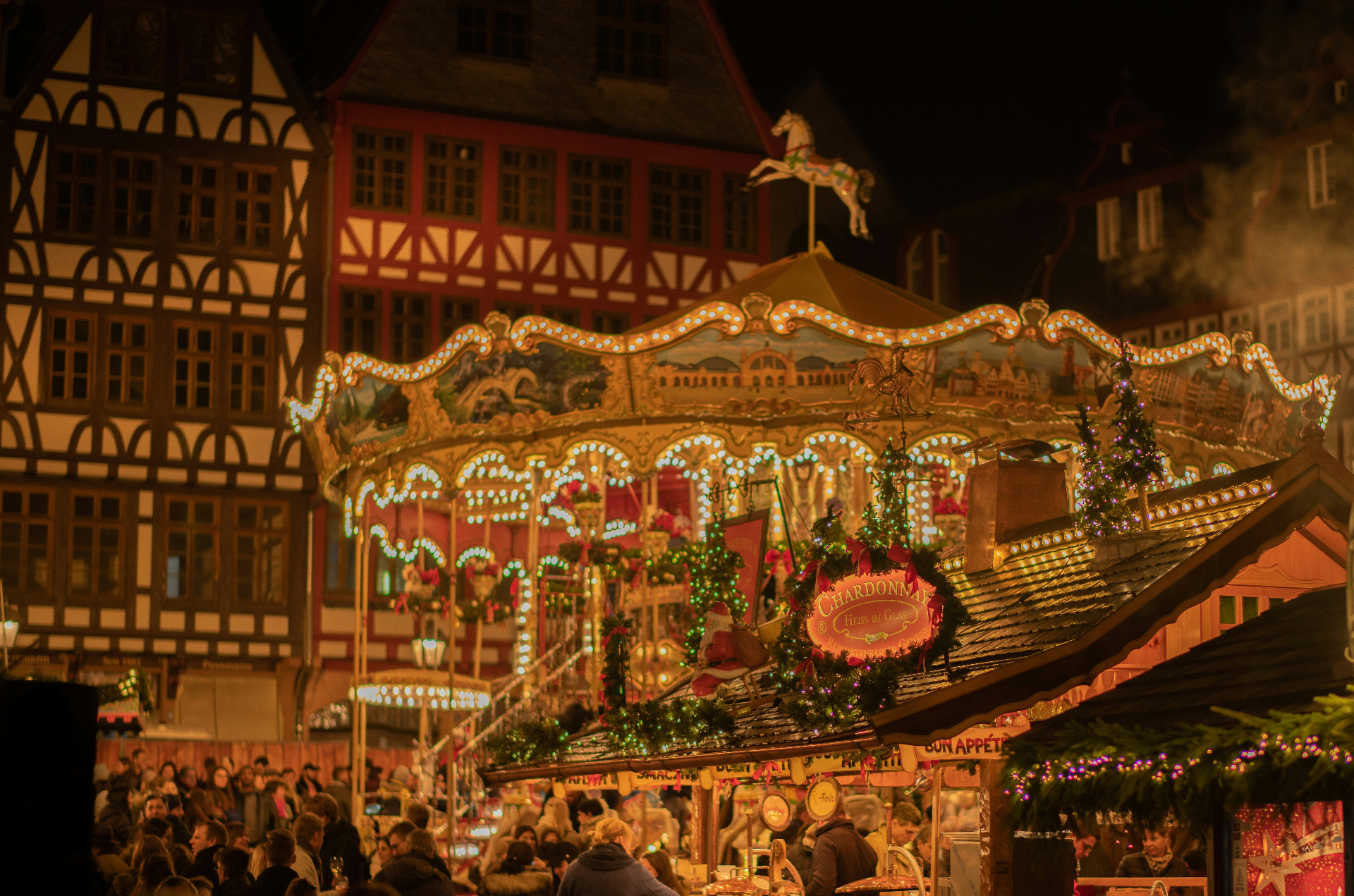 Mercado de Natal europeu com bancas de madeira iluminadas, neve e decorações festivas