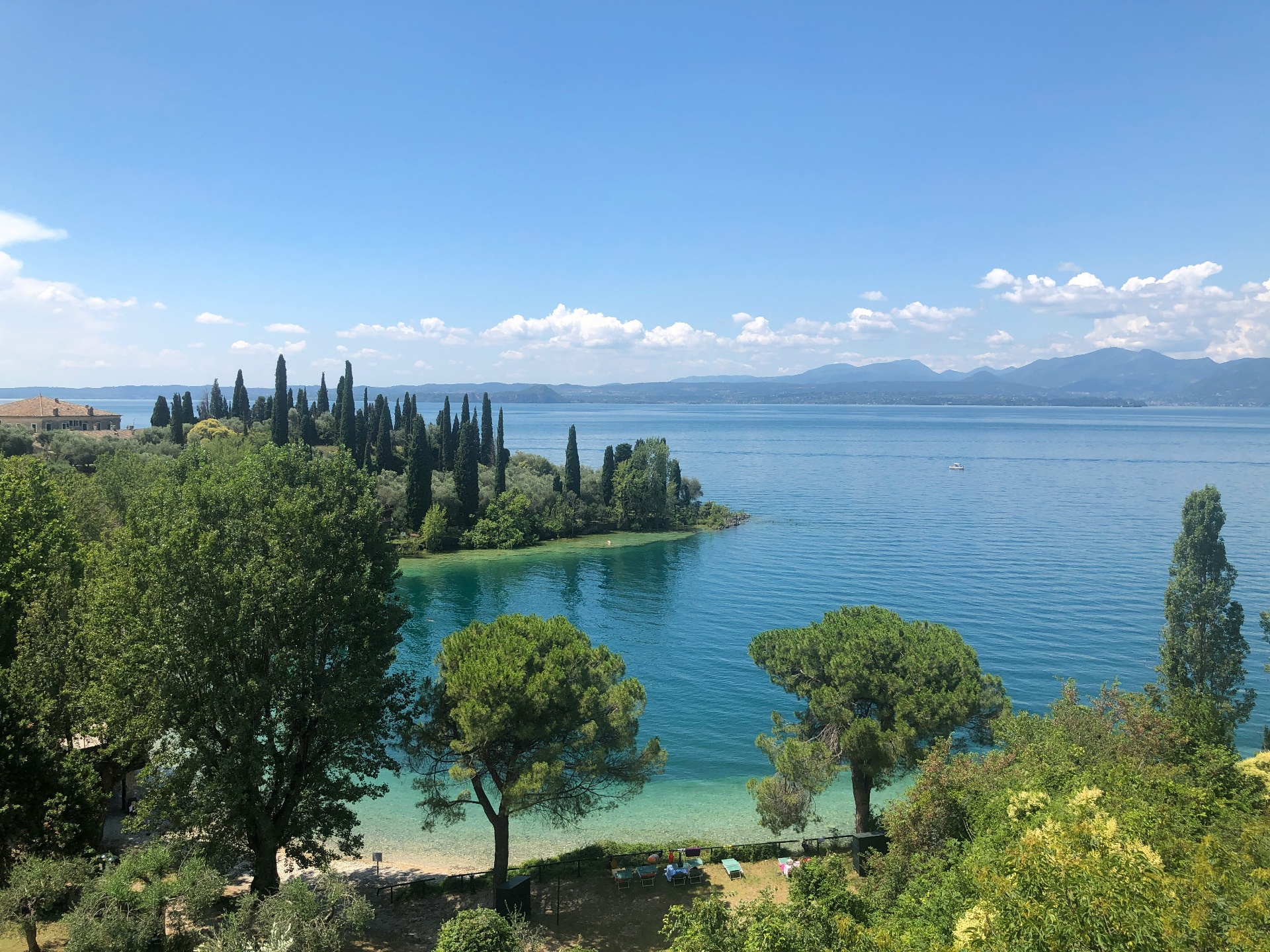 Vista panorâmica do Lago de Garda com águas cristalinas e ciprestes