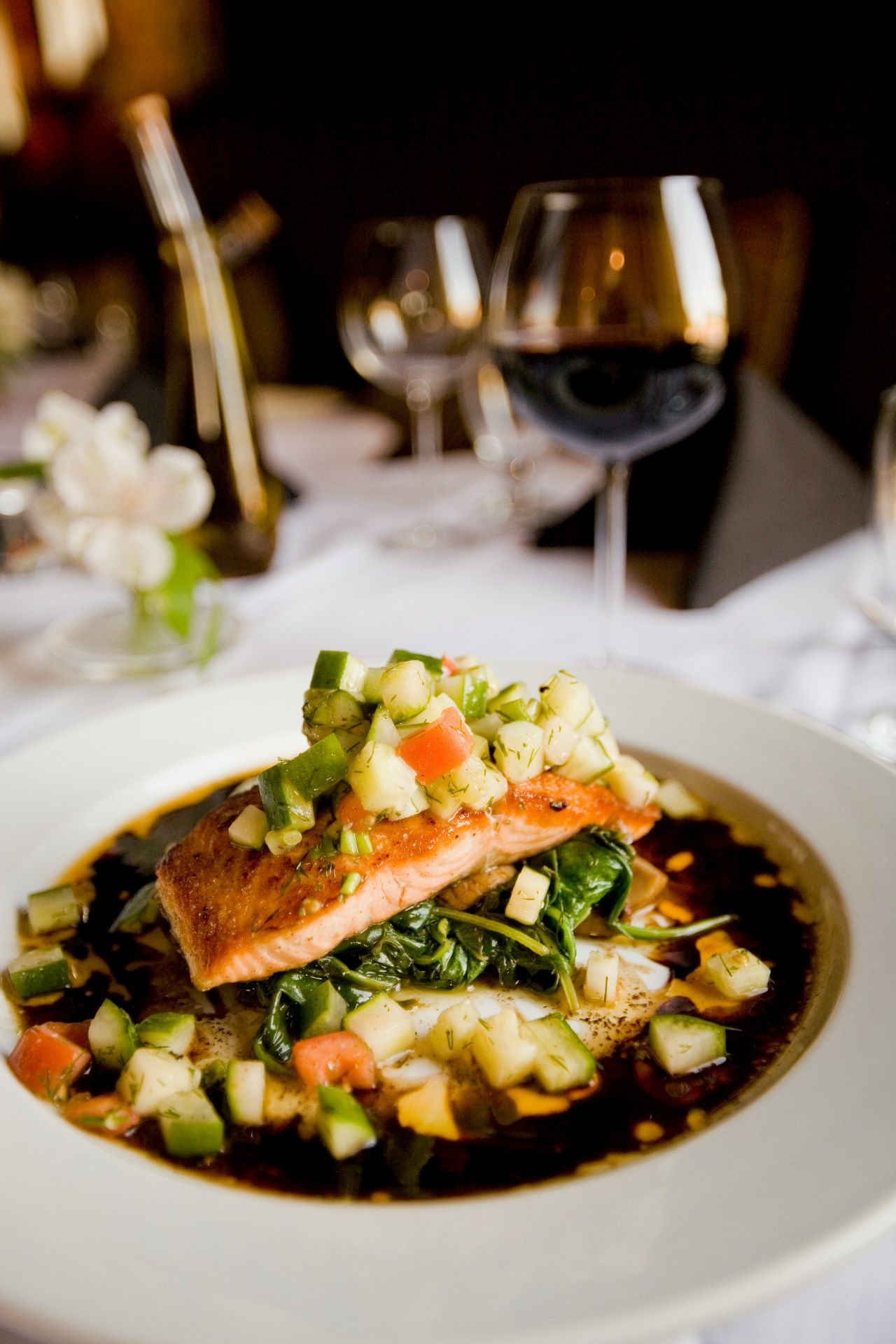 Salmão grelhado com legumes e taça de vinho tinto - exemplo de refeição elegante em Portugal