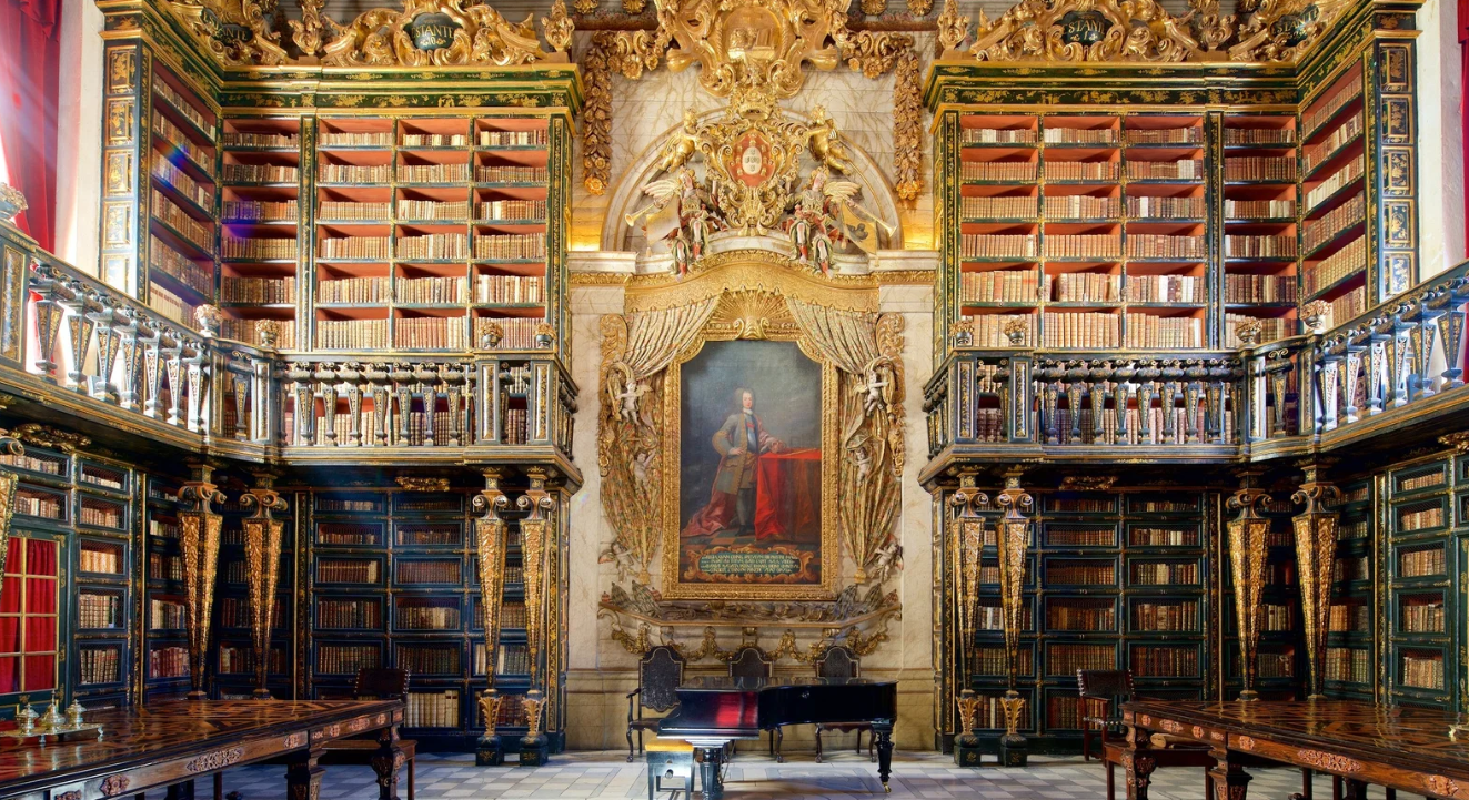 Interior da Biblioteca Joanina - uma das bibliotecas mais belas do mundo, com estantes barrocas douradas e pintura de D. João V
