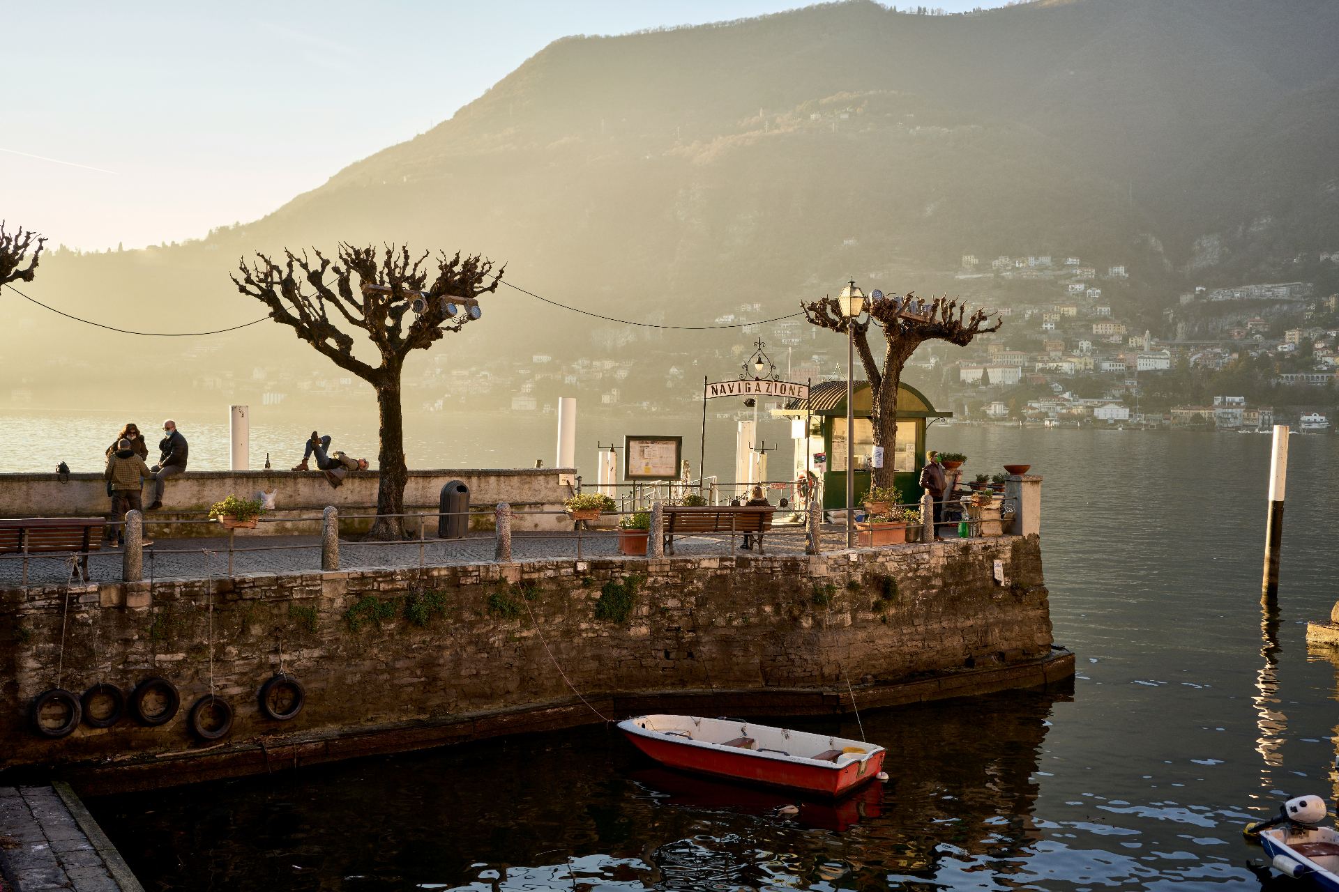 Lago di Como en Lombardía, Italia - vista del muelle con barcos y montañas al fondo