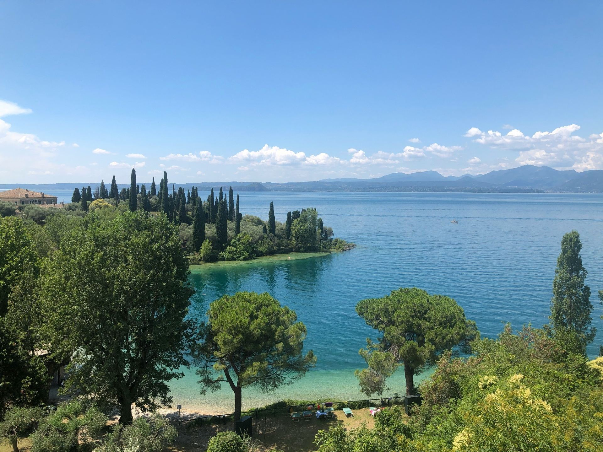 Lago di Garda en Italia - aguas cristalinas con cipreses y montañas
