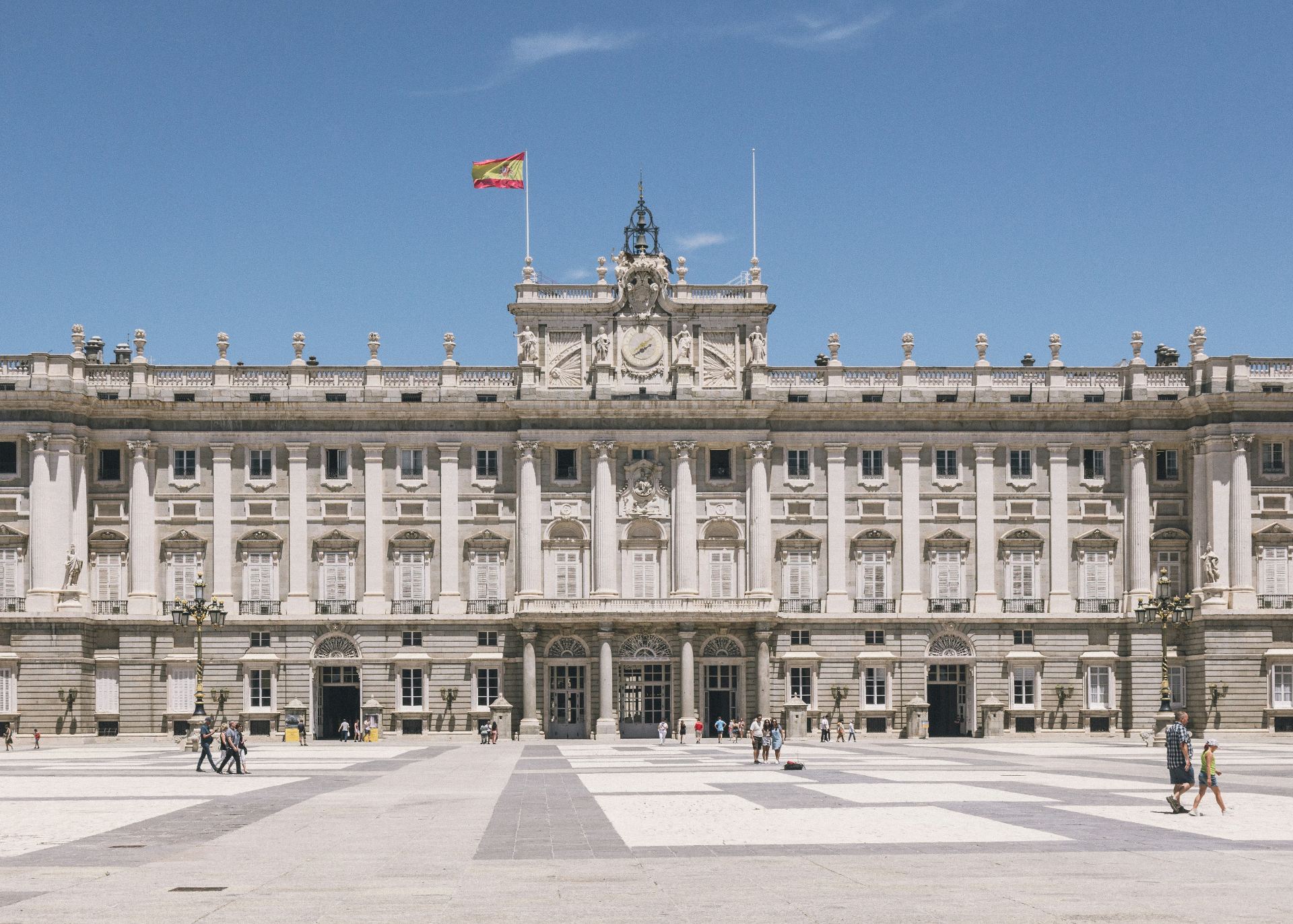 Main facade of the Royal Palace of Madrid with the Spanish flag
