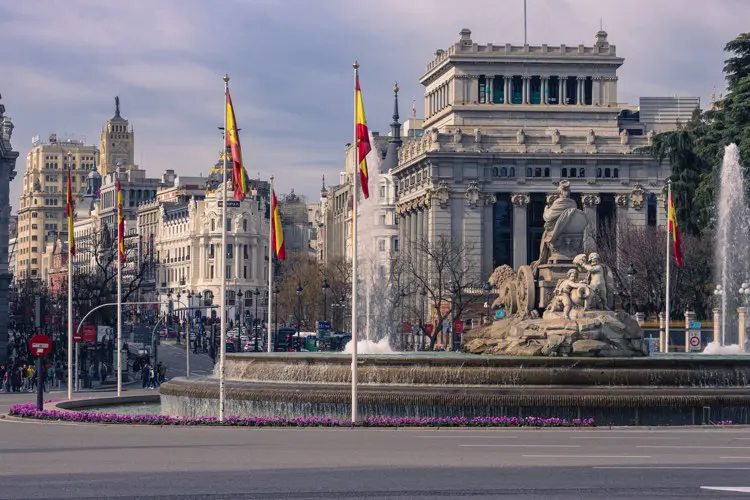 Plaza de Cibeles in Madrid with the iconic fountain and Spanish flags