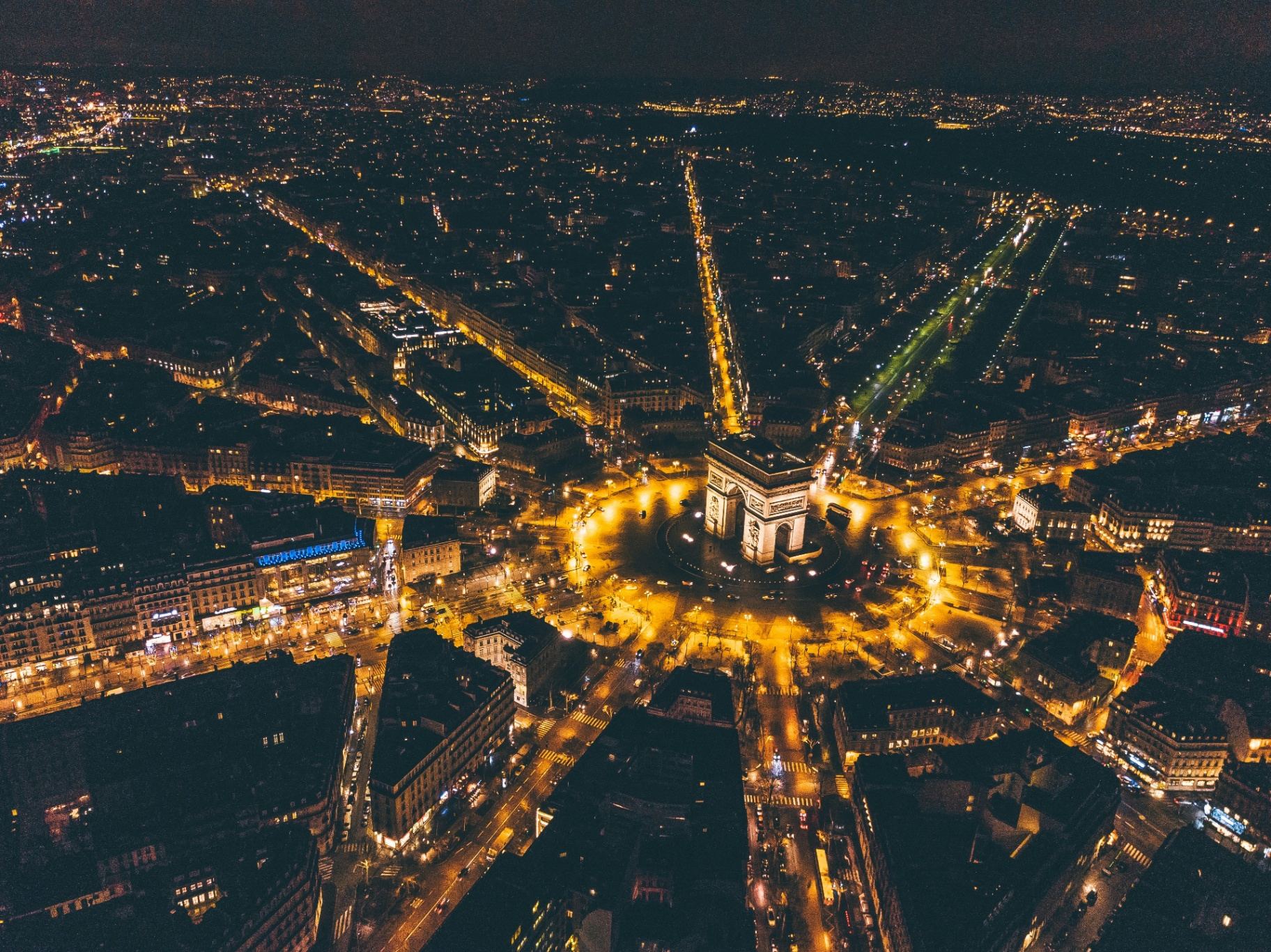 Vista aérea das avenidas de Haussmann em Paris ao pôr do sol com Sacré-Cœur ao fundo