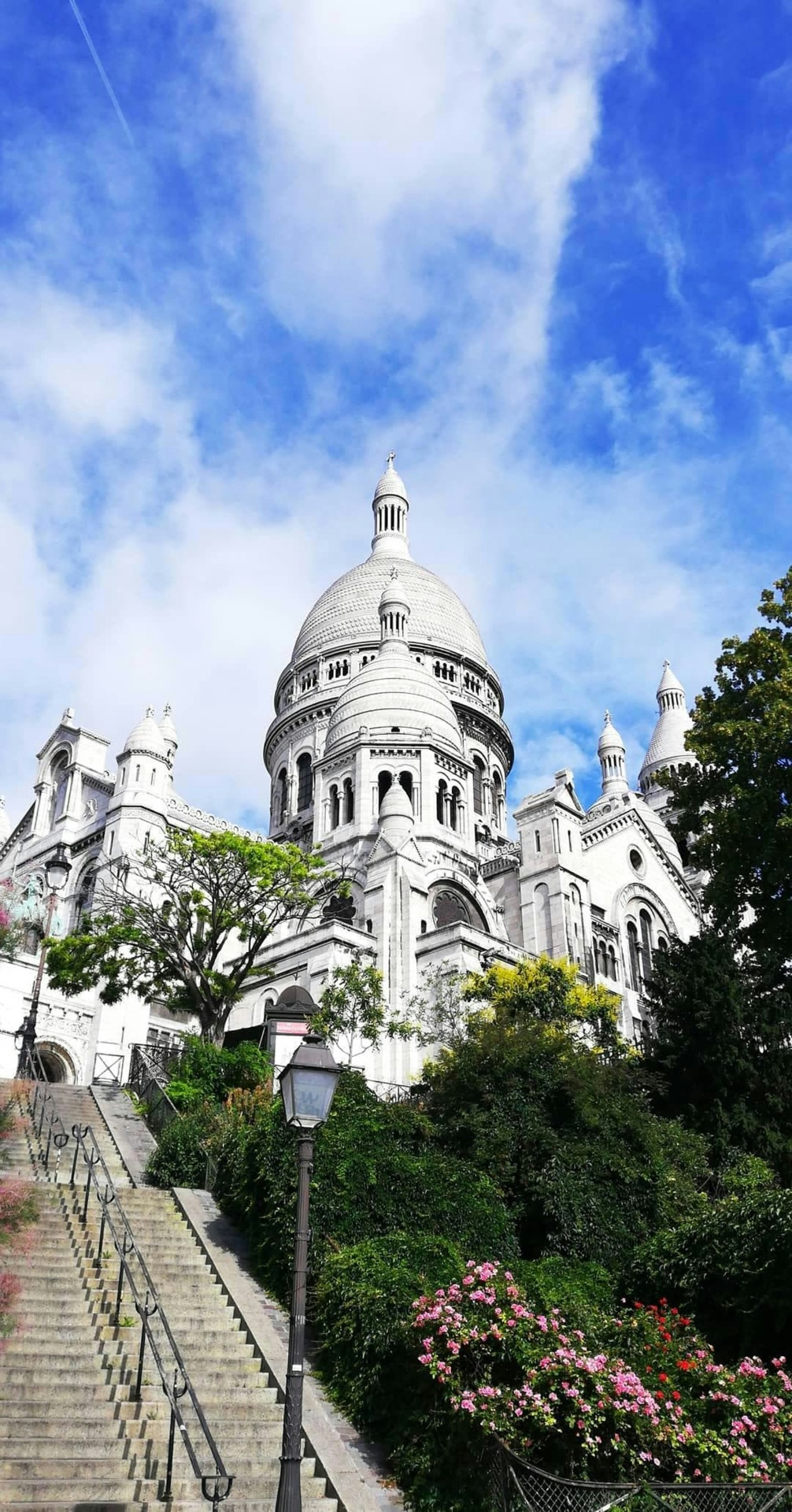 Basílica do Sacré-Cœur com escadarias e jardins floridos
