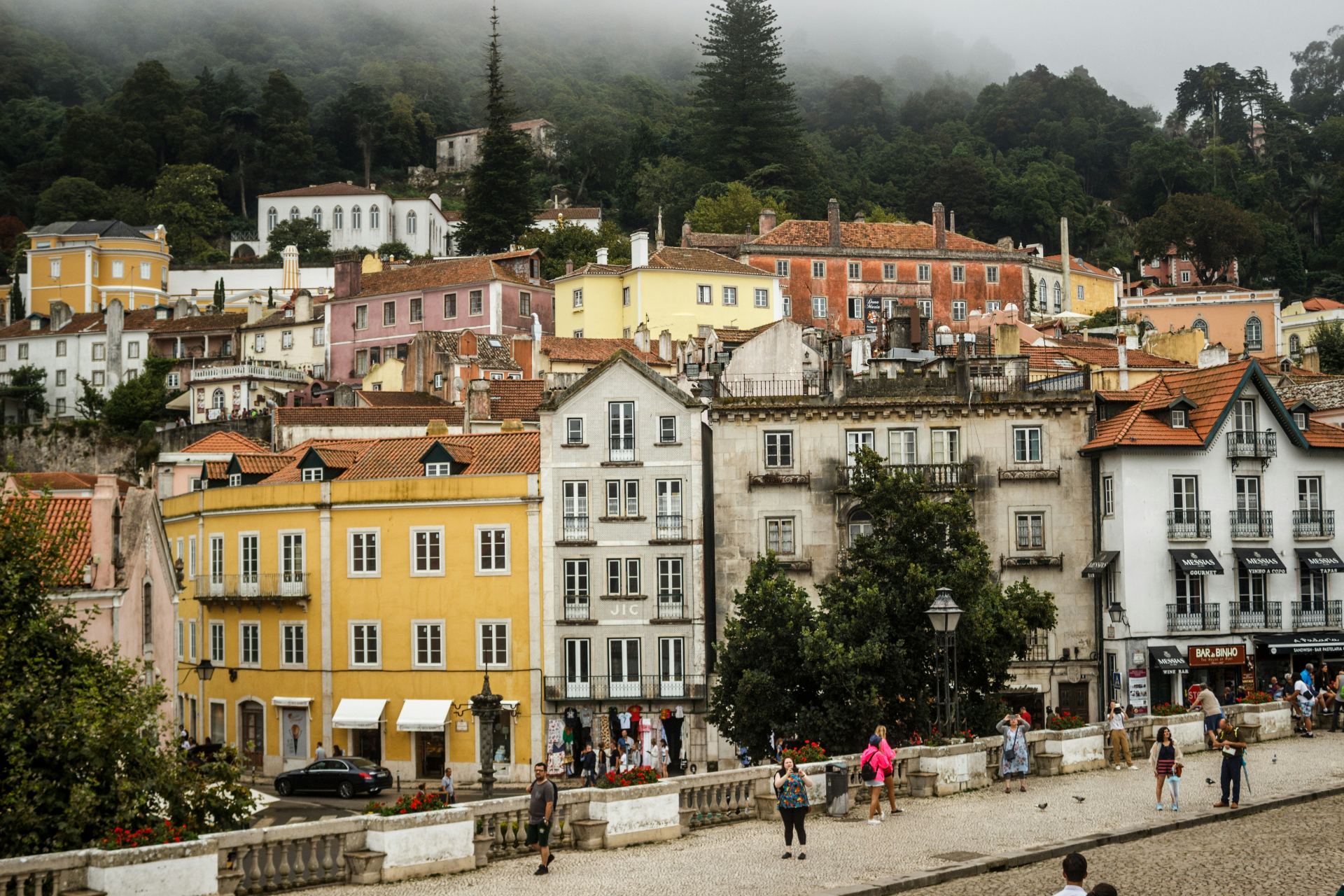Centro histórico de Sintra com casas coloridas, névoa na serra e arquitetura tradicional portuguesa